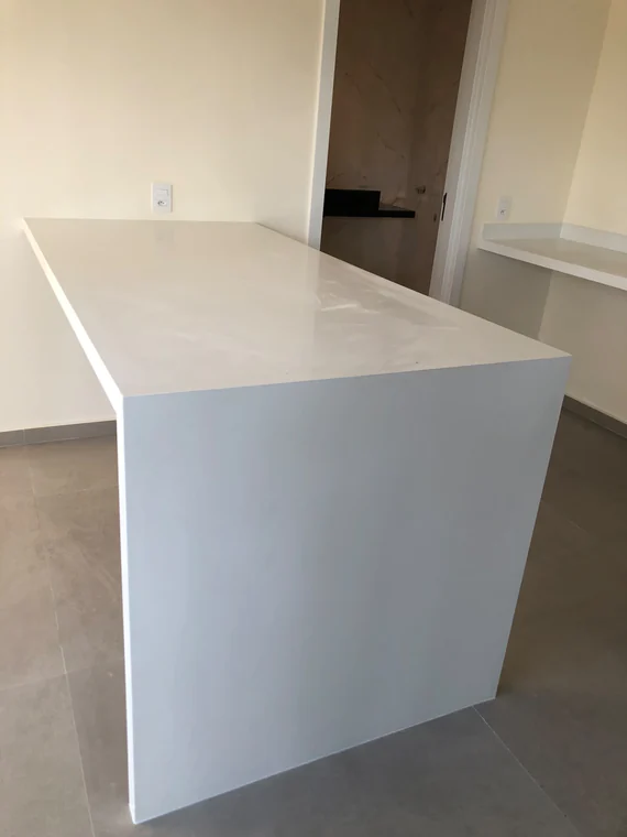 Ilha de cozinha com acabamento branco e laterais fechadas